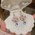 Close-up of colorful flower drop earrings with iridescent crystals in a shell box - Flower Hook Earrings / Hook Style / Gold-Pink