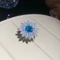 Close-up of elegant flower ring with vibrant blue zircon and sparkling stones - Sunflower Shape Ring