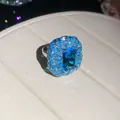 Detail view of an ornate blue zircon flower ring with intricate beadwork textures. - Luxury Floral Ring