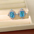 Primo piano di eleganti orecchini in zircone blu in montature d'argento decorate. - Gioielli con perno in argento / Argento-Blu