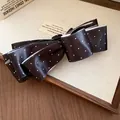 Détail d'une pince à cheveux vintage à nœud en satin noir avec des pois blancs. - Pince Banane / Noir