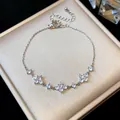 Detailed view of a silver zircon flower bracelet displayed on a beige jewelry box - Flower Style / Silver-White