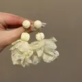 Nahaufnahme eleganter weißer Mesh-Blumenquastenohrringe, perfekt für den Strandurlaub - Silber-Ohrstecker-Stil / Weiß