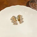 Detail view of irregular geometric clip-on earrings with sparkling cubic zirconia crystals - Irregular Geometric Style / Ear Clip (Pair) / Gold