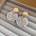 Nahaufnahme von eleganten gold-silbernen, ausgehöhlten Hängeohrringen in einem Display - Rund Hohl Stil / Gold