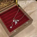 Elegante collana color argento con ciondoli a croce, stella di zirconi e perla in scatola. - Argento