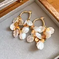 Vue détaillée de créoles plaquées or 18 carats avec d'élégants glands en coquillage - Style Gland de Coquillage / Plaqué Or 18K / Or