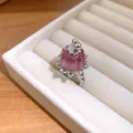 Close-up of a delicate pink resin pudding ring with zircon accents in a beige jewelry box slot - Ring / Silver-Pink