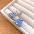 Close-up of blue resin pudding earrings with pastel zircon stones in a jewelry box. - Stud Earrings / Silver-Blue