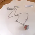 Silver-toned necklace featuring a pink resin pudding pendant and heart zircons on a plate. - Necklace / Silver-Pink