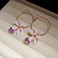 Macro view of rose gold hoop earrings with resin flowers and pink zircon pendants - Flower Dangle Hoop (HE32185) / Rose Gold/Pink