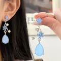 Detailed close-up of blue floral rhinestone teardrop earrings for women - Earrings (HE32818) / Silver-Blue