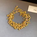 Detailed shot of an irregular geometric gold tassel bracelet with vintage style - Bracelet / Gold