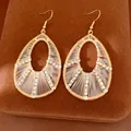 Vue détaillée de boucles d'oreilles gouttes d'eau dorées avec des strass étincelants. - Crochets d'oreilles - Or - Blanc