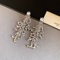 Detailed macro shot of irregular geometric silver fringe earrings with clear zircon stones - Earrings / Silver