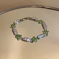 Detail of elegant silver bracelet featuring green flower clusters and rectangular zircons. - Green / Silver