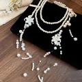 Close-up detail showing the intricate shell flowers on multilayer pearl necklace - Necklace Style / White