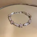 Macro detail of an elegant flower bracelet with pink zirconia and clear crystal accents. - Pink / Silver