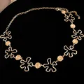 Detailansicht der goldfarbenen Metall-Taillenkette mit Blumen- und Rundmotiven - Gold