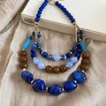 Gros plan d'un collier ethnique multicouche avec des perles en résine bleues et brunes - Bleu-Marron