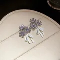 Close-up of elegant flower and white bow stud earrings with sparkling zircons - Flower Bow Stud Earrings / Light Yellow