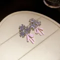 Close-up of elegant floral zircon stud earrings featuring pink enamel bow charms - Flower Bow Stud Earrings / Pink