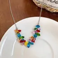 Detailed view of a vibrant colorful beaded necklace with a silver chain on a white ceramic plate. - Necklace - Silver - Multicolor