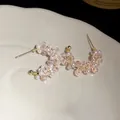 Macro view of elegant C-shaped earrings with pink glass beads and white pearls - Pink