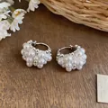 Detailed macro view of French style pearl cluster hoop earrings on a rustic wood surface - Hoop Style / Silver-White