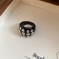 Close-up of black resin ring with polished silver circular metal rivets - Rivet Decorated Ring