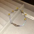 Detailed view of luxury silver tennis bracelet featuring yellow zircons and signature H-clasp - Silver-Yellow