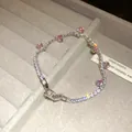 Close-up of zircon bracelet with pink round stones on gray jewelry display tray. - Silver-Pink