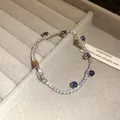 Detailed view of silver zircon bracelet with purple gemstones on grey display. - Silver-Purple