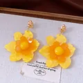 Detalle de pendientes de flores de resina amarilla y naranja vibrantes con agujas de plata. - Estilo de Flor (HE34018) / Amarillo