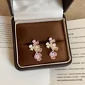Primo piano di eleganti orecchini a lobo a fiore con smalto colorato in una scatola - Rosa (Perno per orecchino in argento)