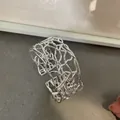 Vista dettagliata del bracciale rigido argento minimalista con motivo a trama scavata - Stile Intrecciato Traforato Irregolare (2#) / Argento
