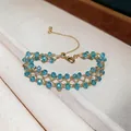 Macro detail of a handmade gold lattice bracelet with sparkling light blue crystal beads. - Blue Beaded / Gold