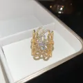 Elegante anello aperto con fiore traforato e zirconi scintillanti in finitura dorata - Fiore Traforato / Oro