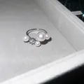Macro detail of elegant silver-toned open ring with pearls and brilliant zircon stone - Style 5 Ring