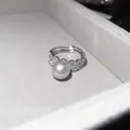 Close-up of a silver pearl ring with sparkling zircon flowers in a luxury velvet jewelry box - Style 2 Ring