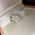 Primo piano dettagliato di orecchini a margherita con grandi perle bianche. - Argento (Perno in argento)