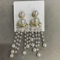 Elegant white pearl tassel drop earrings with golden accents on a white display card - Long Tassel / Gold