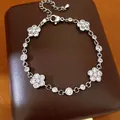 Close-up of elegant silver-colored bracelet featuring zircon-encrusted flower motifs - Floral Round Style / Silver