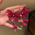Detail view of deep rose red fabric flower earrings with long pearl tassels and zirconia - Rose Red