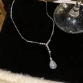 Detailed macro view of a sparkling teardrop zircon pendant necklace on black velvet background - Water Drop Pendant Necklace / Necklace - Silver