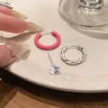 Primo piano di orecchini in argento con smalto, cerchio a spirale e perno in zircone. - Combinazione Cerchio Argentato e Borchia in Zirconia / Rosa Rosso