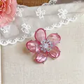 Nahaufnahme eines eleganten rosa Blumen-Ohrclips mit funkelnder Zirkonia-Mitte auf Spitze - Einzelne Ohrmanschette / Silber-Rosa