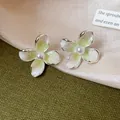 Eleganti orecchini a lobo a forma di fiore verde sfumato con una perla centrale. - Verde
