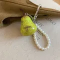 Detail of a yellow-green pear-shaped charm with a white pearl beaded loop strap - Pear Shaped Bag Charm / With Artificial Pearl Beads and Heart Clasp