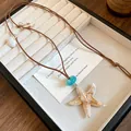 Detail showing a handmade starfish and shell necklace for tropical beach holidays - Starfish / Coffee